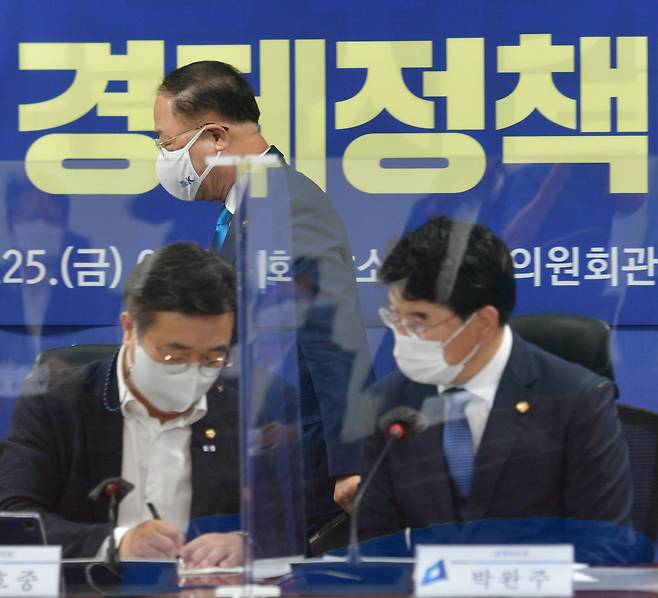 홍남기 부총리 겸 기획재정부 장관(가운데)이 25일 서울 여의도 국회 의원회관에서 열린 더불어민주당 2021 하반기 경제정책방향 당정협의에 참석하고 있다. 윤호중 원내대표(왼쪽)와 박완주 정책위의장이 논의하고 있다. [연합]