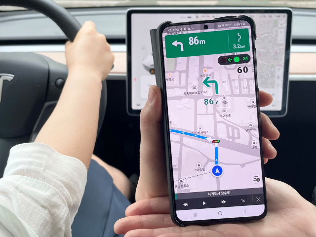 제주 서귀포시에서 KT 모델이 KT 원내비의 교통신호 정보를 실시간으로 받아 주행하는 모습을 보여주고 있다. /사진 제공=KT