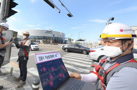 내년 9월까지 강릉시 지능형교통체계 기반구축사업자로 LG유플러스 컨소시엄이 선정돼 기술협상을 마치고 본계약을 체결했다. 강릉역 앞에서 LG유플러스 직원들이 27일 스마트횡단보도 서비스에 필요한 카메라를 설치하고 있다. LG유플러스 제공