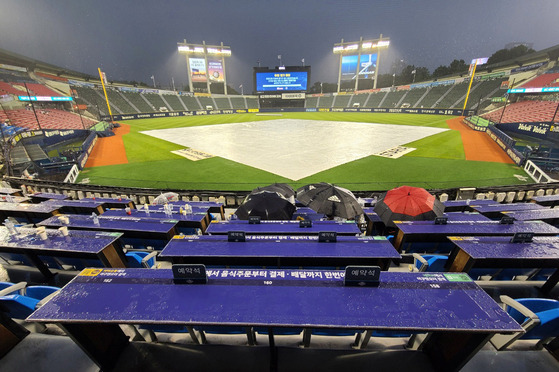 A game between the Doosan Bears and Lotte Giants is stopped due to heavy rain at Jamsil Baseball Stadium in southern Seoul on Sunday. [NEWS1]