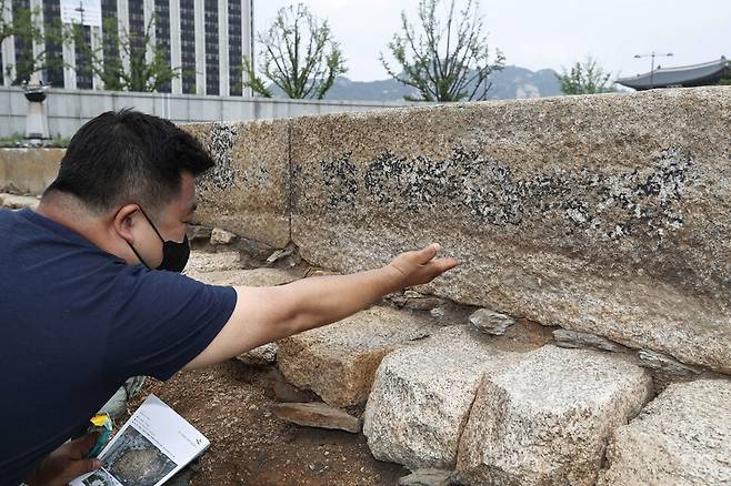 조치욱 서울역사박물관 학예연구사가 의정부 터에서 발굴된 정본당 기단에 대해 설명하고 있다. 오른쪽 위 석재에 검은색으로 보이는 부분이 조선시대 지면 위로 노출됐던 부위다.