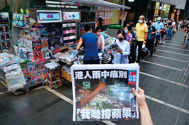 홍콩의 대표적 친민주화 매체 빈과일보의 '마지막 신문'을 사려는 시민들이 6월24일 시내 가판대 앞에 길게 줄지어 서 있다. &copy; AP 연합