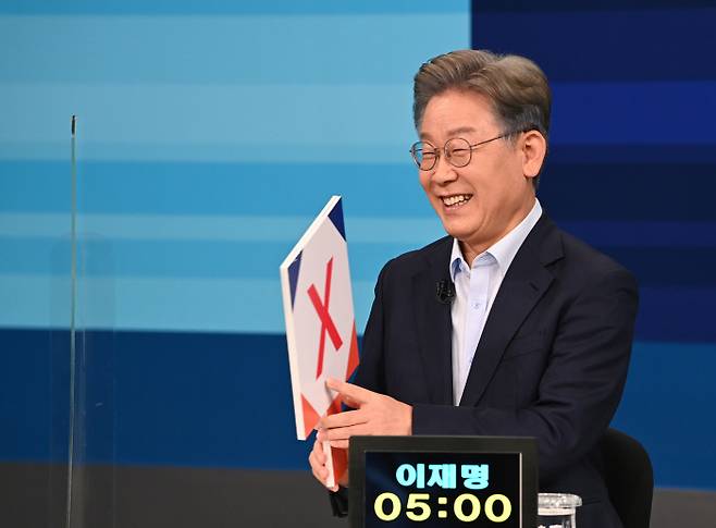 더불어민주당 대선 경선 예비후보인 이재명 경기도지사가 5일 오후 서울 마포구 상암동 JTBC 창조관 스튜디오에서 JTBC와 MBN 공동주최로 열린 예비경선 2차 합동 TV토론회를 앞두고 OX퀴즈판을 들고 웃고 있다. 국회사진기자단.