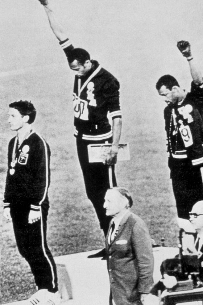 1968년 멕시코시티 올림픽 남자 육상 200m에서 금메달을 딴 토미 스미스(가운데)와 동메달리스트 존 카를로스(오른쪽)가 시상대에서 검은색 장갑을 낀 주먹을 치켜들며 인종차별에 항의하는 시위를 하고 있다. ㅣ게티이미지