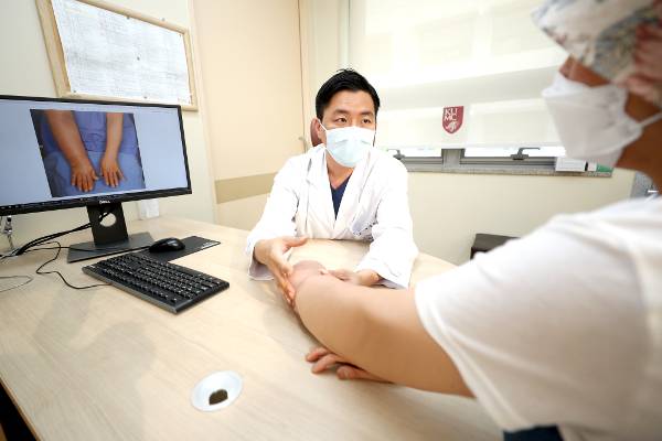 고려대 구로병원 성형외과 문경철 교수가 양쪽 유방암 수술 후 림프부종이 생긴 50대 환자의 팔을 살펴보고 있다. 압박 스타킹이나 마사지 등 보존적 치료에 한계를 보이는 환자들에게 수술로 림프부종을 완화하는 방법이 최근 각광받고 있다. 고려대 구로병원 제공