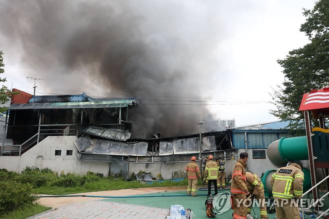 검은 연기 뿜어내는 화재 현장 (광주=연합뉴스) 천정인 기자 = 12일 오전 광주 광산구 우산동 한 생활용품 창고에서 불이나 소방대원들이 화재진압을 하고 있다. 창고에 쌓인 부탄가스 등 인화물질로 진화에 어려움을 겪으면서 소방당국은 대응 1단계를 발령했다. 2021.7.12 iny@yna.co.kr