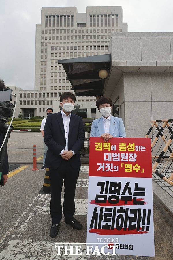이준석 국민의힘 대표(왼쪽)가 13일 오전 서울 서초동 대법원 앞에서 김명수 대법원장 사퇴를 촉구하며 릴레이 1인 시위를 하고 있는 김은혜 의원을 격려하고 있다. /국회사진취재단