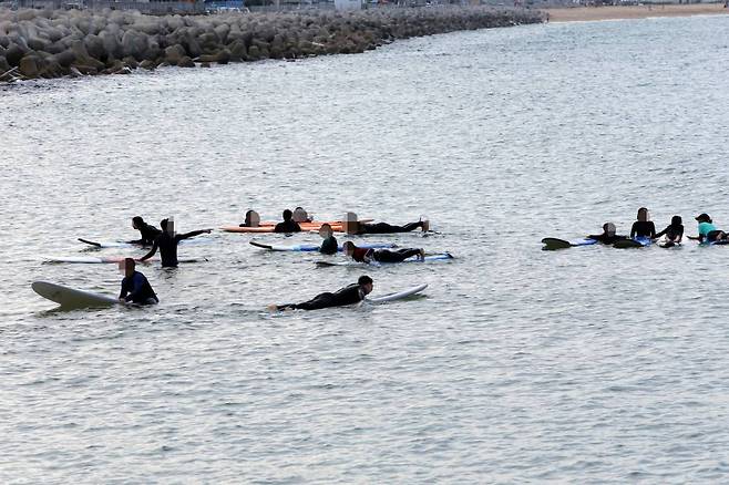 지난 11일 오후 서퍼들이 강원도 속초시 속초해수욕장에서 서핑을 즐기고 있다. 서퍼들 전원이 마스크를 쓰지 않은 상태다. 사진=뉴시스