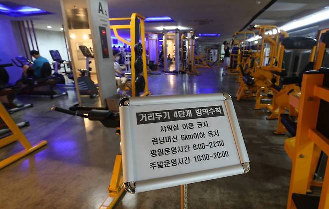 사회적 거리두기 4단계 첫날인 12일 서울 은평구 연신내 한 헬스장에서 관계자가 런닝머신 등 기구 방역을 하고 있다. 헬스장에서는 샤워실을 이용할 수 없고 런닝머신은 6km 이하의 속도를 유지해야 한다. /사진=뉴시스