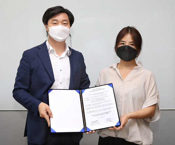 Korea JoongAng Daily Managing Editor Lee Moo-young (left) and Korizon Esports founder Ashley Kang pose for a photo after signing a memorandum of understanding at the Korea JoongAng Daily office in western Seoul on Wednesday. [PARK SANG-MOON]