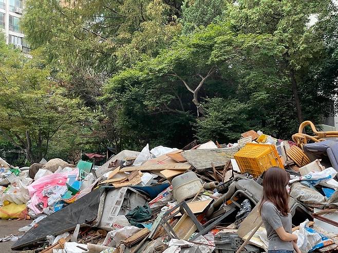 지난 9일 오전 서울 대치동 은마 아파트 지상 주차장의 한복판에 쓰레기가 쌓여있다. 키 165㎝인 기자(사진)가 까치발을 들고 봐도 정상(?)을 보기 쉽지 않을 정도다.&nbsp;