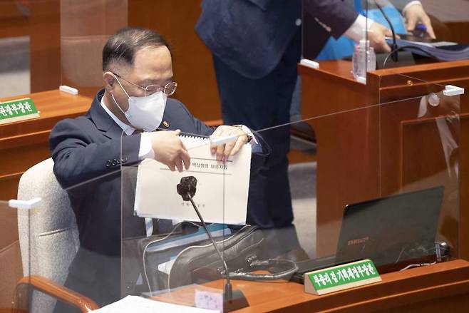[서울=뉴시스] 최동준 기자 = 홍남기 부총리 겸 기획재정부 장관이 15일 서울 여의도 국회에서 열린 예산결산특별위원회 전체회의에서 자료를 꺼내고 있다. (공동취재사진) 2021.07.15. photo@newsis.com