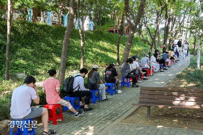 서울 광진구 보건소 선별진료소를 찾은 시민들이 16일 오전 인근 공원 산책로에 마련된 의자에 앉아 더위를 피하며 순서를 기다리고 있다. 이석우 기자