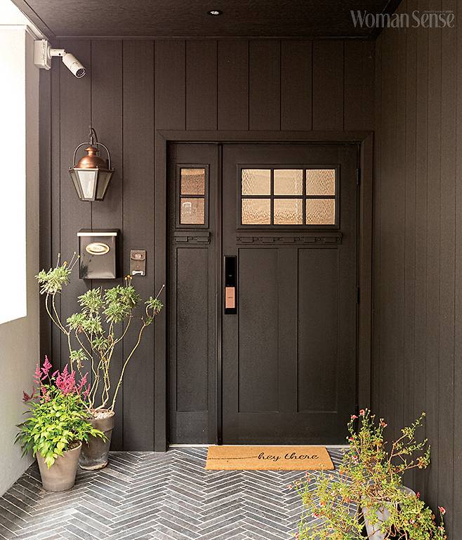 인더스트리얼 무드로 꾸며진 현관. 초록 식물이 생기를 더한다.