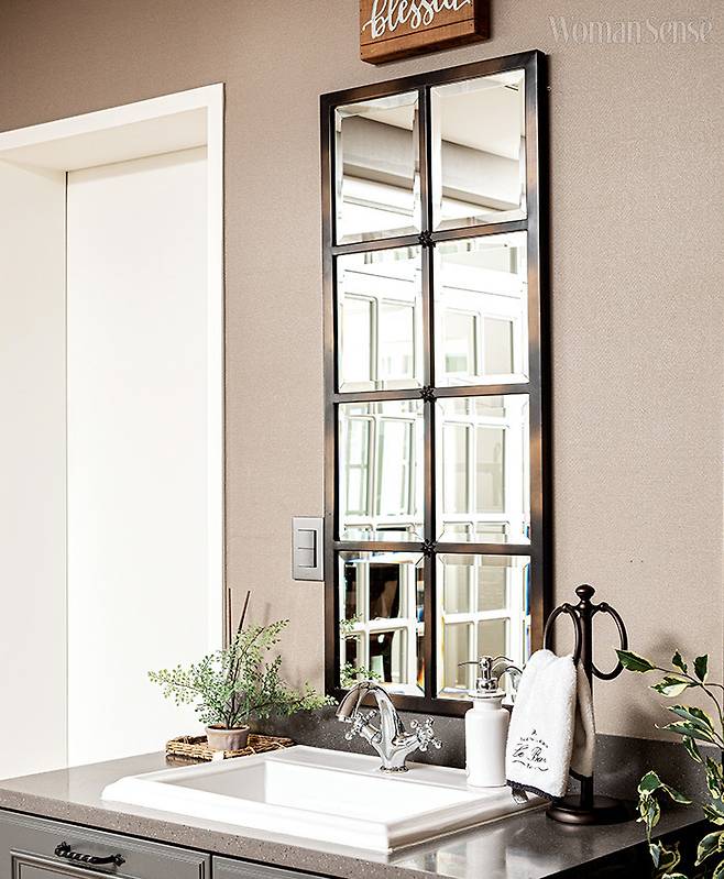 욕실과 세면대를 분리해 멀티룸 내에 따로 설치했다. 손님들이 편하게 손을 씻을 수 있어 유용하다. 격자 거울로 포인트를 주었다.