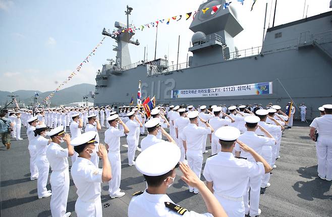 경남 창원시 진해구 진해 군항 내 정박 중인 마라도함 비행 갑판에서 지난달 28일 열린 마라도함 취역식에서 장병들이 거수경례를 하고 있다. 함교 중앙 상부에 다기능위상배열(AESA) 레이더 구조물이 설치되어 있다. 창원=뉴스1