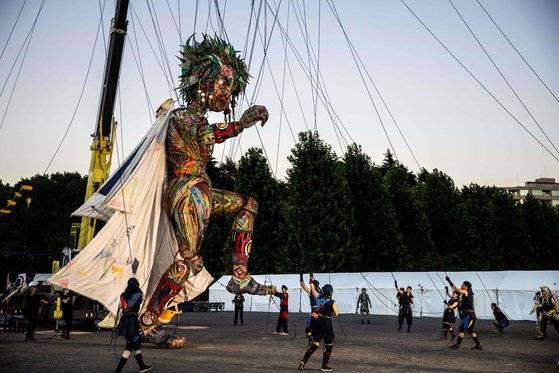 17일 일본 도쿄 신주쿠교엔에서 10미터 높이의 대형 인형 '못코'가 사람들이 당기는 줄에 따라 춤을 추고 있다. [AFP=연합뉴스]