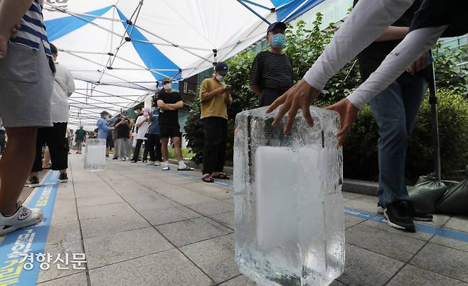 ‘연일 폭염에’…선별진료소에 얼음 등장 폭염이 이어진 20일 오전 서울 관악구보건소 선별진료소에 검사를 받기 위해 줄을 서 있는 시민들을 위한 얼음이 놓여 있다. 김창길 기자 cut@kyunghyang.com