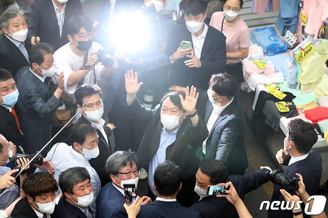 야권 대선주자인 윤석열 전 검찰총장이 20일 낮 대구 서문시장을 찾아 상가 연결통로에 환영 나온 시민들을 향해 손을 흔들어 인사하고 있다. 2021.7.20/뉴스1 © News1 공정식 기자