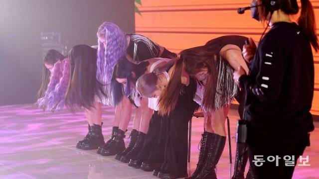 트라이비 가 쇼케이스를 시청하는 팬들에게 허리를 굽혀 인사하고 있다.