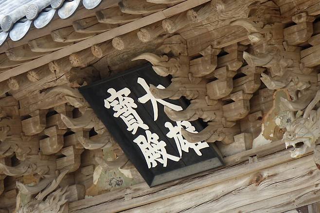 미황사와 대웅보전 현판. 미황사의 대웅전은 다른 절집에서는 흔한 단청마저도 벗어버린 채 그저 수수한 모습이다.