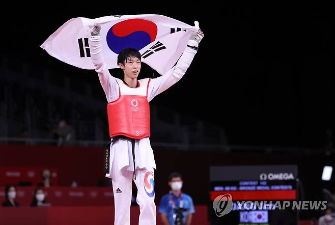[올림픽] 장준, 자랑스러운 동메달 (지바=연합뉴스) 손형주 기자 = 24일 일본 마쿠하리 메세 A홀에서 열린 도쿄올림픽 남자 태권도 58㎏급 경기에서 동메달을 획득한 장준이 태극기를 들고 세리머니를 하고 있다. 2021.7.24 handbrother@yna.co.kr