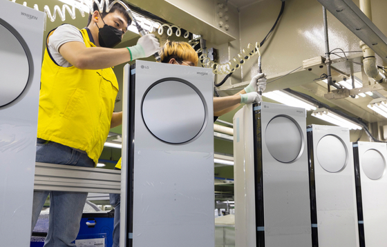 An employee assembles air conditioners at an LG Electronics factory in Changwon, South Gyeongsang. The company announced on Sunday that its production line is operating at full capacity amid high demand for air conditioners during the heat wave. [YONHAP]