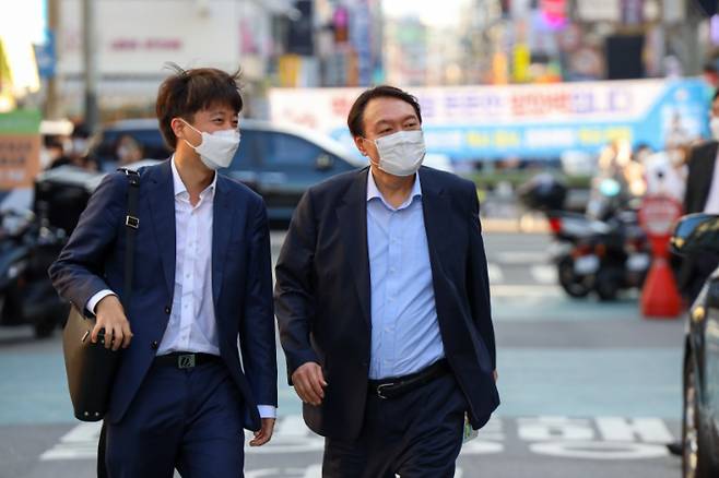 국민의힘 이준석 대표와 윤석열 전 검찰총장이 25일 오후 서울 광진구 건대맛의거리에서 '치맥회동'을 하기 위해 한 음식점으로 향하고 있다. 윤석열 캠프 제공 윤석열 캠프 제공