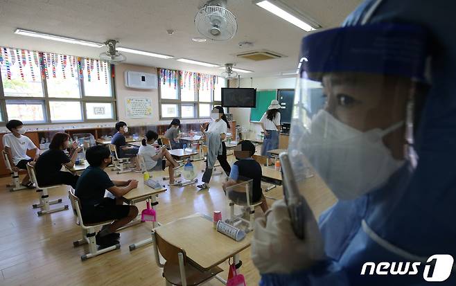 대전 한 초등학교 학생들을 대상으로 의료진이 신종 코로나바이러스 감염증(코로나19) 전수검사를 실시하기 위해 준비하고 있다. 2021.7.22/뉴스1 © News1 김기태 기자