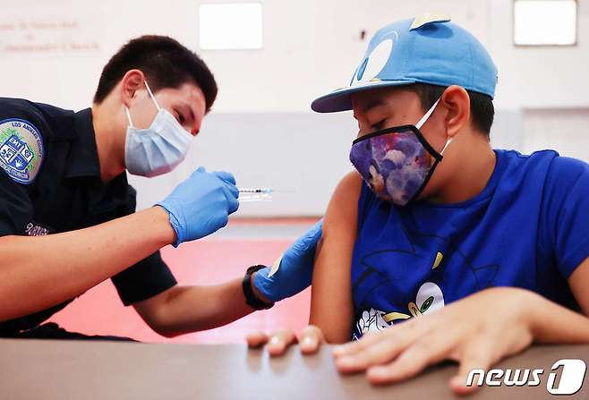 미국 캘리포니아 위네트카 한 중학교에 마련된 코로나19 백신 임시 접종소에서 2021년 7월 6일 중학생 알렉스 페레스가 백신을 맞고 있다.  © AFP=뉴스1