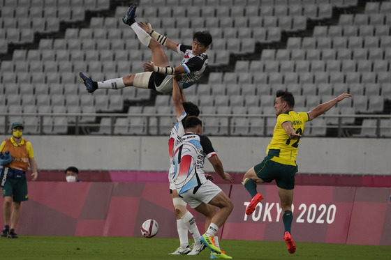 Korea's Jeong Yeon-sik is lifted in the air by teammate Lee Jink-yu during a lineout in a rugby sevens match against Australia at the 2020 Tokyo Olympics on Monday. [AP/YONHAP]