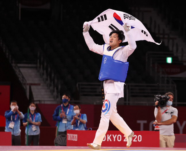 27일 일본 마쿠하리 메세홀에서 열린 도쿄올림픽 남자 태권도 80㎏ 초과급 동메달 결정전 한국 인교돈-슬로베니아 트라이코비치. 인교돈이 승리 후 태극기를 흔들고 있다. 도쿄 | 연합뉴스