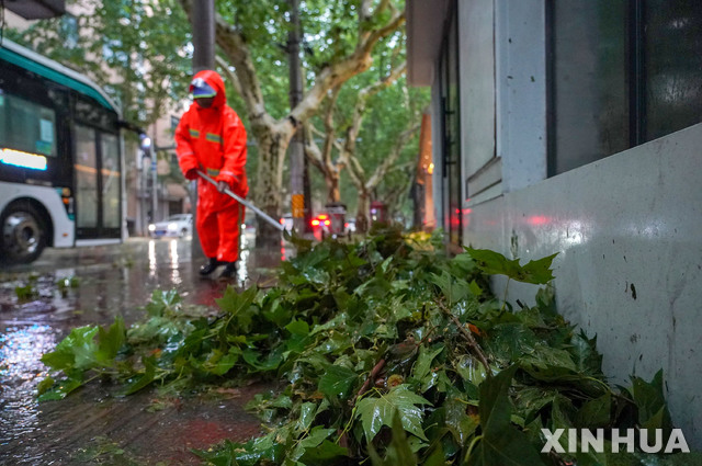 [상하이=신화/뉴시스] 25일 중국 상하이에서 환경미화원이 제6호 태풍 인파 영향으로 강풍에 쓰러진 나뭇가지를 청소하고 있다. 2021.07.27.