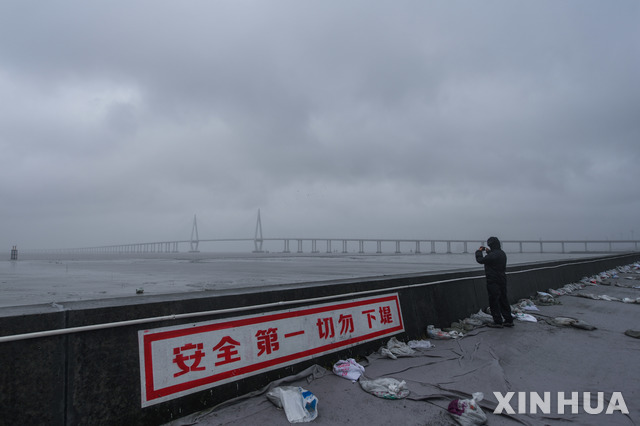 [핑후=신화/뉴시스] 25일 중국 저장성 자싱 핑후항에서 직원이 순찰을 하고 있다. 이날 중국에 제6호 태풍 인파가 상륙했다. 2021.07.27.