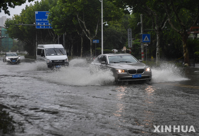 [핑후=신화/뉴시스] 26일 중국 저장성 자싱 핑후에서 차량이 침수된 도로를 달리고 있다. 이날 중국에 제6호 태풍 인파가 상륙했다. 2021.07.27.