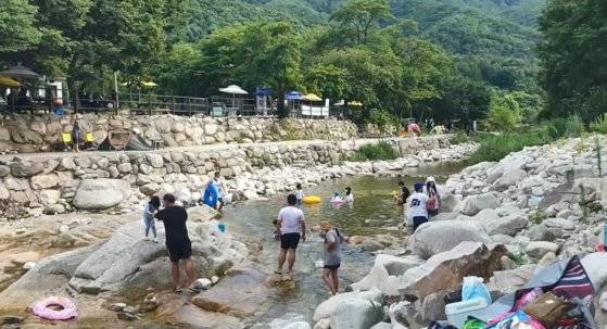 불법 시설물이 철거되고 정비된 경기도 포천시 이동면 백운계곡의 현재 모습. 지난 26일 오후 기암괴석 사이로 맑은 물이 흐르는 자연 계곡에서 피서객들이 물놀이 중이다. 전익진 기자