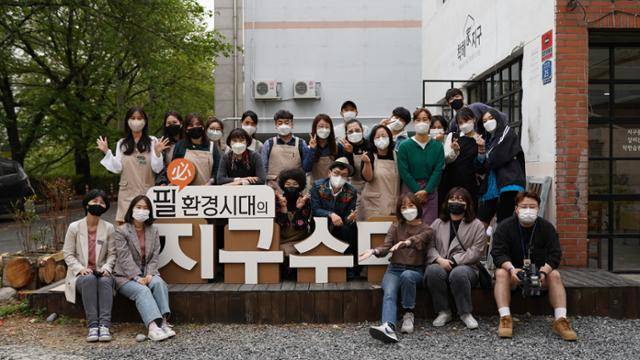 UBC 울산방송이 자사 프로그램인 '필환경시대의 지.구.수.다' 제작을 위해 지난 4월 선보인 울산 최초의 자원순환가게 앞에서 시민운영진 15명과 제작진이 포즈를 취하고 있다. 울산 UBC 제공