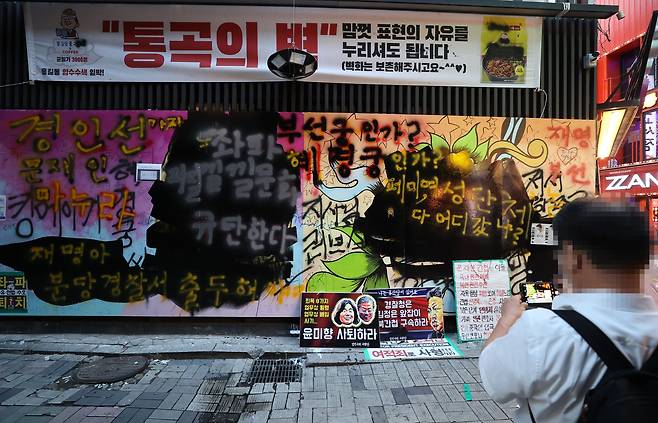 한 유튜버가 31일 이른바 '쥴리 벽화'에 검은색 페인트칠을 한 모습./연합뉴스