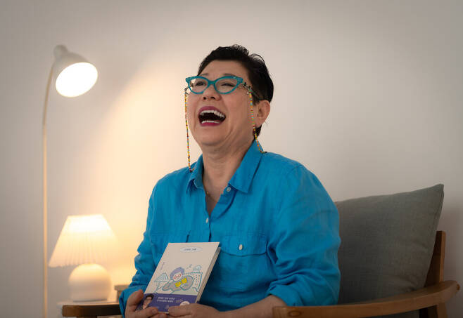 가수 양희은씨가 본인의 저서 <그러라 그래>를 들고 웃고 있다. 사진 이승원 작가