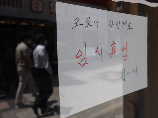 지난 23일 서울 시내 한 식당에  ‘코로나 4단계로 임시휴업합니다’고 적힌 안내문이 붙어있다. 정부는 다음달 8일까지 현재 거리두기 4단계를 연장하기로 했다.(사진=연합뉴스)