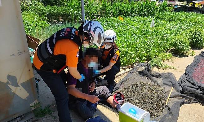 충남소방본부 폭염119구급대가 지난달 1일 홍성군 갈산면에서 열경련 환자를 응급처치하고 있다. 충남소방본부 제공