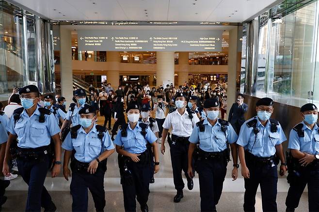 홍콩 경찰이 지난 30일 홍콩보안법 위반 혐의를 받은 홍콩 청년 통잉킷에 대한 재판이 열린 법원에서 통잉킷 지지자들에게 나가달라고 요구하고 있다. 홍콩/로이터 연합뉴스