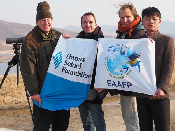 아마엘 볼체(오른쪽 둘째) 교수가 북한 나진 지역 조사 현장에서 프로젝트를 지원한 독일 한스자이델재단 등의 깃발을 들고 기념사진을 찍었다. 촬영은 나일 무어스 박사가 했다. 사진 새와 생명의 터 제공