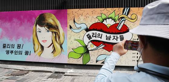 A photo of the wall paintings outside a bookstore in Jongno District, central Seoul, which refer to rumors that Yoon Seok-youl's wife worked as a hostess at a nightlife establishment under the alias of Julie. On the right, the caption says, ″Julie's dream! Becoming the first lady!″ On the left, the center of the red heart reads, ″Julie's men.″ [NEWS1]
