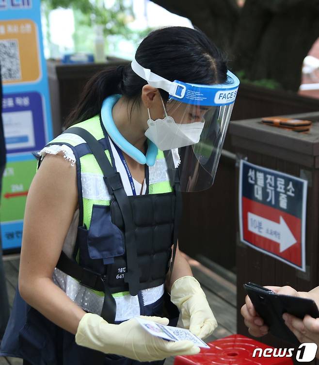 서울 광진구 보건소 선별진료소에서 의료진이 얼음조끼를 입은 채 시민들을 안내하고 있다.© News1 구진욱 기자
