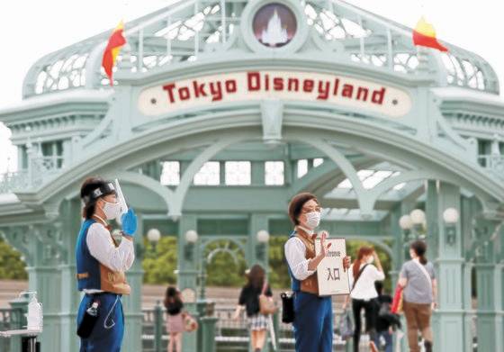 지난해 7월 1일 입장객을 맞고 있는 도쿄 디즈니랜드의 모습. 코로나19로 인해 직원들이 마스크를 쓴 채 안내하고 있다. 도쿄 디즈니랜드의 입장료는 전세계에서 가장 저렴한 수준이다. 로이터=연합뉴스