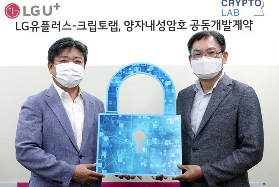 LG U+ Vice President Choi Taek-jin, left, stands with Cheon Jung-hee, founder and CEO of cryptographic company CryptoLab, holding a lock-shaped prop after signing an investment deal on Sunday. LG U+ will invest in CryptoLab to build a 5G and 6G network safe from quantum computer attacks, the telecom company said. [LG U+]