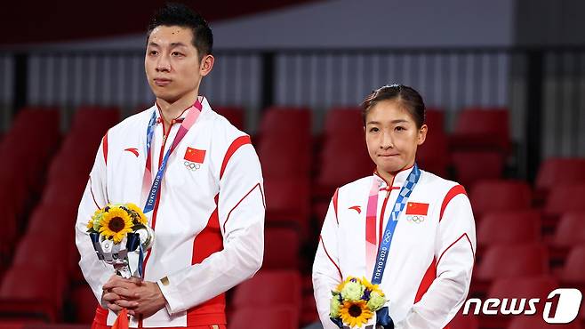 중국 혼합 복식조가 은메달을 따고 시상대에 올랐지만 표정이 어둡다. © 로이터=뉴스1 © News1 박형기 기자