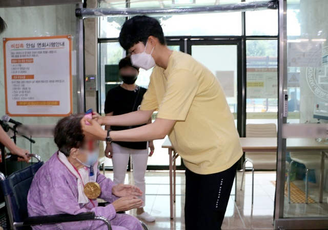 2020도쿄올림픽 양궁 '3관왕'을 거머쥔 안산 선수가 지난 2일 오후 광주 모 병원에 입원한 외할머니 목에 금메달을 걸었다. /사진=뉴시스(독자제공)