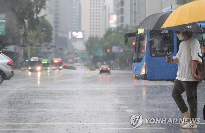 폭염 속 소나기  1일 서울 종로구 도로에서 시민들이 우산을 쓴 채 발걸음을 옮기고 있다. [연합뉴스 자료사진]